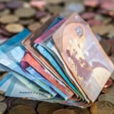 A pile of money sitting on top of a pile of coins